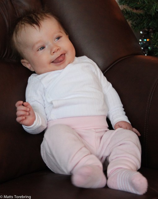 Nelly, lika glad på juldagens morgon sittandes i mormor och morfars soffa