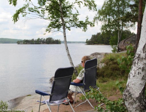 Birgitta sitter och tittar på och fotar premiärdoppet