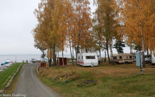 Några husvagnar och husbilar trängs vid stranden